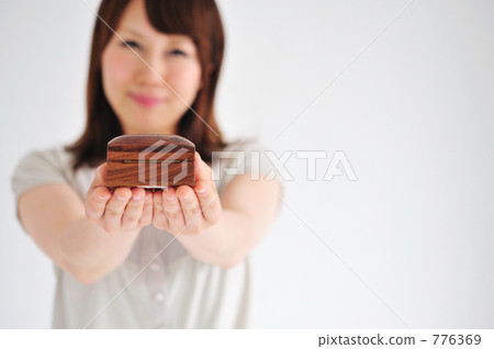 A young woman in her 20s handing over a gift. A young woman in her 20s handing over a gift. 776369