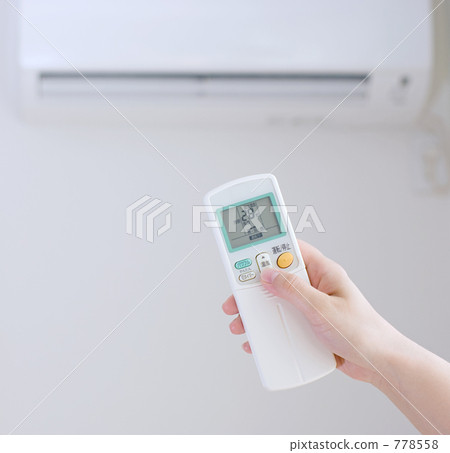 A woman setting air conditioning at 28 ° C A woman setting air conditioning at 28 ° C 778558