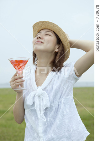 一個女人在草地上喝雞尾酒 一個女人在草地上喝雞尾酒 780678