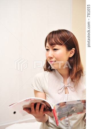 Hey, look at this! A young woman in her 20s is browsing a gift catalog. Hey, look at this! A young woman in her 20s is browsing a gift catalog. 781055