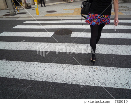 A woman crossing a pedestrian crossing 788019