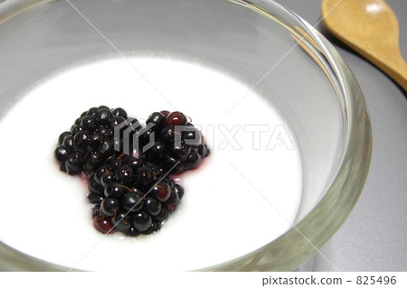Unsweetened yogurt in a glass bowl topped with blackberries. 825496