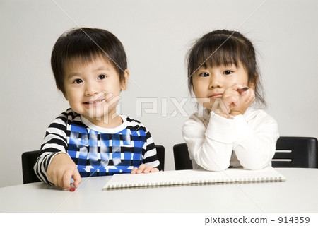 Two people drawing pictures with crayons Two people drawing pictures with crayons 914359