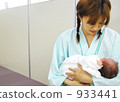 A mother holding a baby 933441