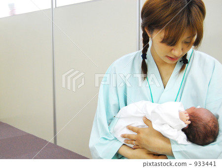 A mother holding a baby 933441