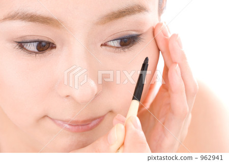 A woman applying mascara 962941