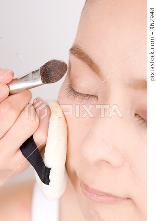 A woman having an eye shadow painted 962948