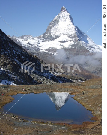 Swiss Matterhorn is beautifully reflected on the lake surface 983381