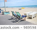 An old couple sunbathering on the South Coast of England 989598