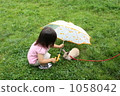 A girl giving an umbrella to a rabbit 1058042