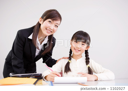 A girl who is instructed by a teacher (second grade elementary school student) 1102027