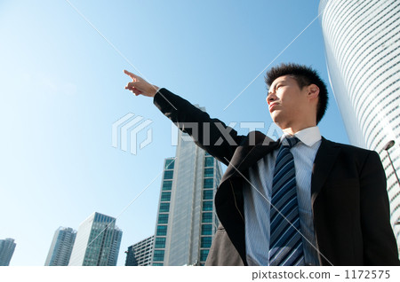 Businessman and skyscraper pointing to the finger 1172575