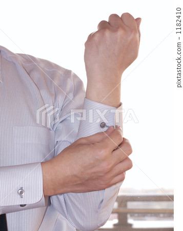 拿著袖子按鈕的男性胳膊 1182410