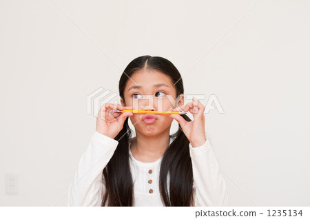 Elementary school student with a pencil on his nose 1235134