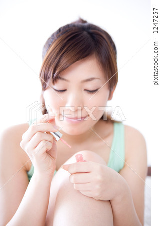 一位年輕的女士畫指甲油 一位年輕的女士畫指甲油 1247257