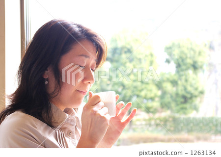 一個女人享受咖啡的香味 1263134