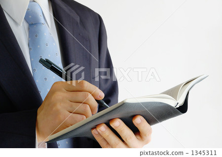 Businessman filling in the notebook 1345311