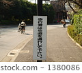 Pedestrians walk on the sidewalk. 1380086
