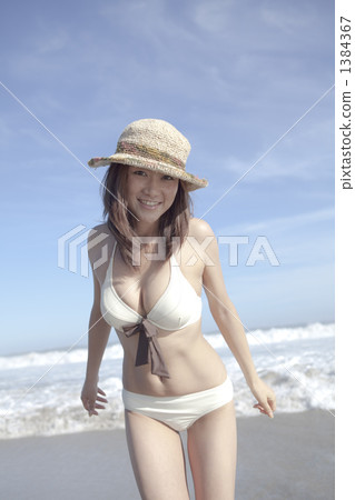 游泳衣的一名婦女在沙子 游泳衣的一名婦女在沙子 1384367