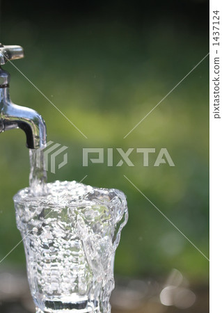 Pour water from the tap into the glass 1437124