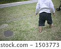 An infant walking barefoot on the lawn 1503773