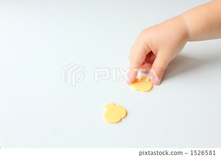 A hand of a child pinching a die-cut cheese 1526581