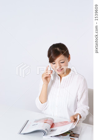 A young lady who calls while reading a magazine 1539609