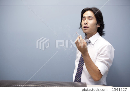 businessman smoking cigarette A businessman smoking a cigarette - Stock Photo [1541327]