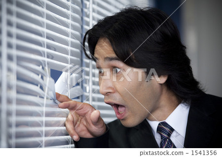 Men Looking Through Blinds Stock Photo