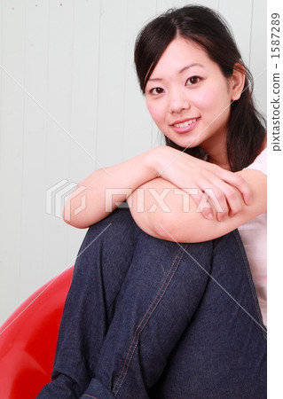 坐在一把紅色椅子的婦女 1587289