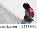 A crouching girl on the road 1588941
