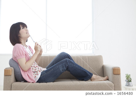 Young woman relaxing on a sofa Young woman relaxing on a sofa 1656480
