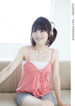 一個年輕女子在沙發上放鬆 一個年輕女子在沙發上放鬆 1668054
