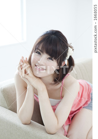 一個年輕女子在沙發上放鬆 一個年輕女子在沙發上放鬆 1668055