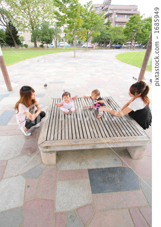 Young mommy fellow and baby playing in the park's eastern shop 1685949