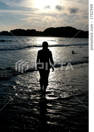 Silhouette of a woman walking in the sea 1782999