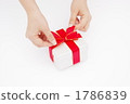 A picture of a woman's hand linking a ribbon to a present A picture of a woman's hand linking a ribbon to a present 1786839