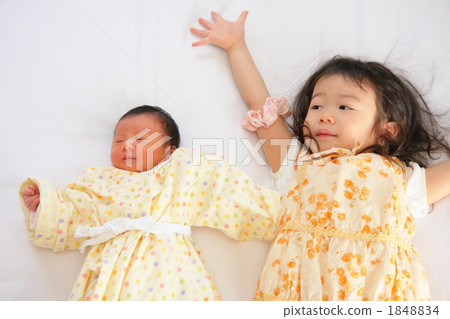 兩歲的妹妹比較新生嬰兒 1848834