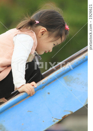 A 2 year old girl climbing up the slide 1926621