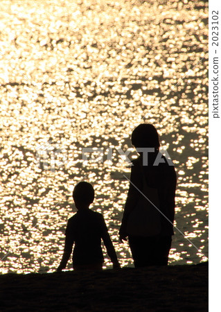 Parent and child walking on the sandy beach of the sunset 2023102