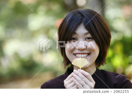 一個女人高興地有銀杏葉的葉子 2062255