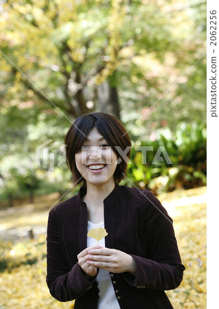 一個女人高興地有銀杏葉的葉子 2062256