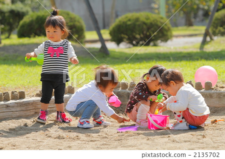 1 year old girls playing in the park sandbox 2135702