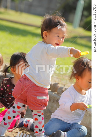 1 year old girls playing in the sandbox 2135706