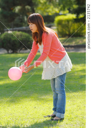 A young mama who releases a ball to a child 2135742