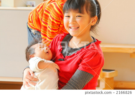 A baby hugged in the arm of a 7-year old sister A baby hugged in the arm of a 7-year old sister 2166826
