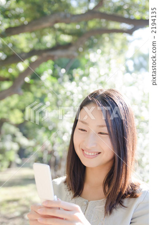 20多歲的女人微笑在移動電話(室外)講話的女人 20多歲的女人微笑在移動電話(室外)講話的女人 2194135