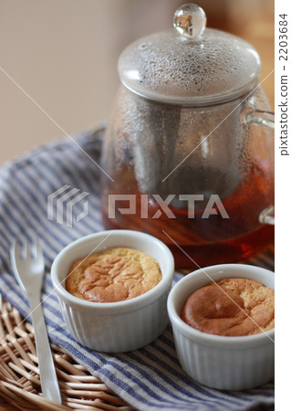 Cheese souffle made in a cocotte and a teapot of hot tea 2203684