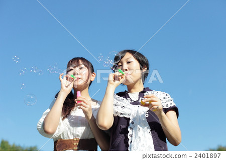 Two young women blowing soap bubbles 2401897