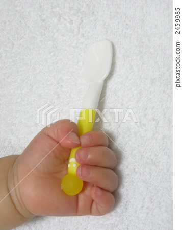 Baby's hand holding a spoon Baby's hand holding a spoon 2459985